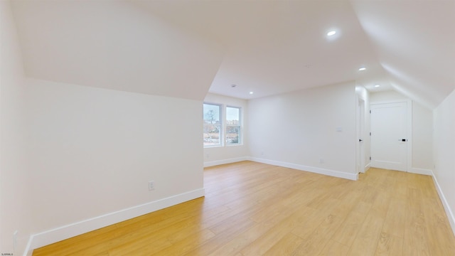 bonus room with lofted ceiling and light wood-type flooring