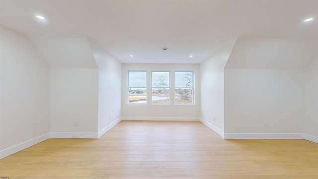 bonus room with lofted ceiling and light wood-type flooring