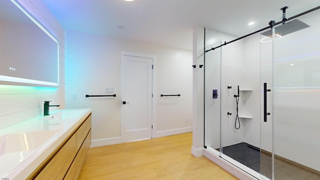 bathroom featuring hardwood / wood-style flooring, vanity, and walk in shower