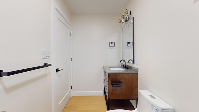 bathroom with wood-type flooring, toilet, and vanity