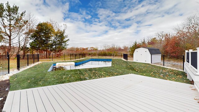 deck with a fenced in pool, a lawn, and a storage unit