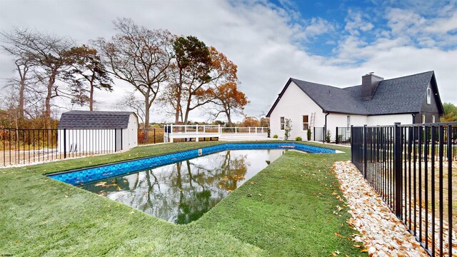 view of pool featuring a lawn and a storage unit