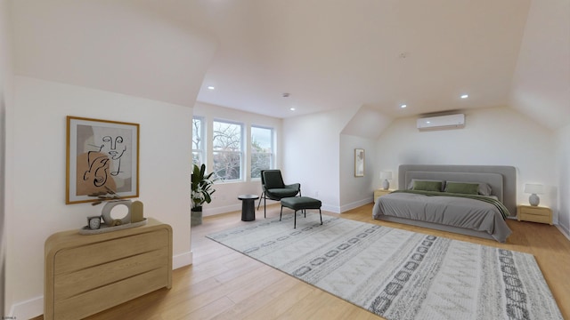 bedroom featuring a wall mounted air conditioner, vaulted ceiling, and light wood-type flooring