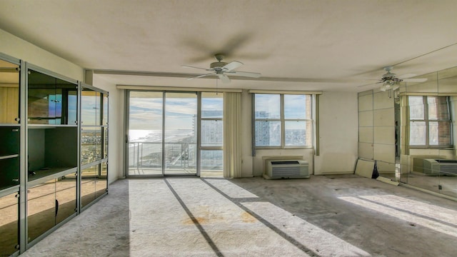 unfurnished living room featuring an AC wall unit and ceiling fan