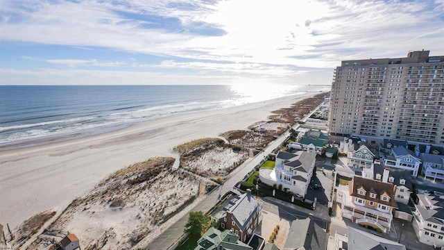 drone / aerial view featuring a beach view and a water view