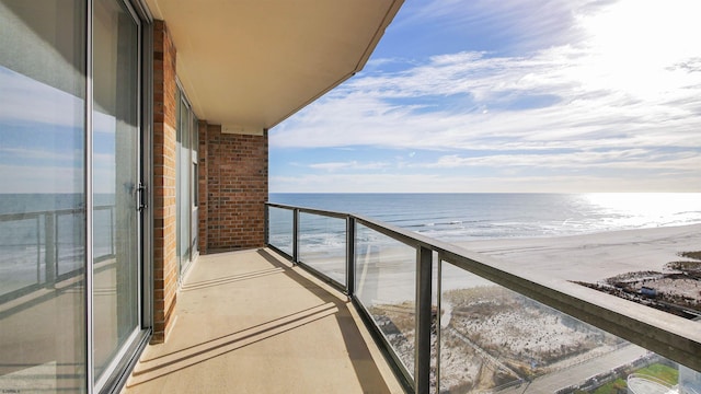 balcony featuring a water view and a view of the beach