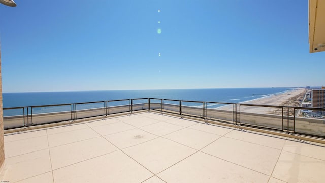 view of patio / terrace with a water view and a beach view