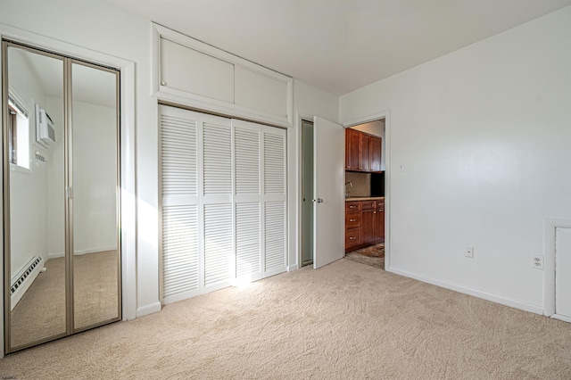 unfurnished bedroom featuring baseboard heating and light colored carpet