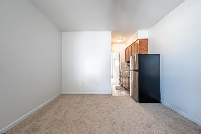 kitchen featuring stainless steel fridge and light colored carpet