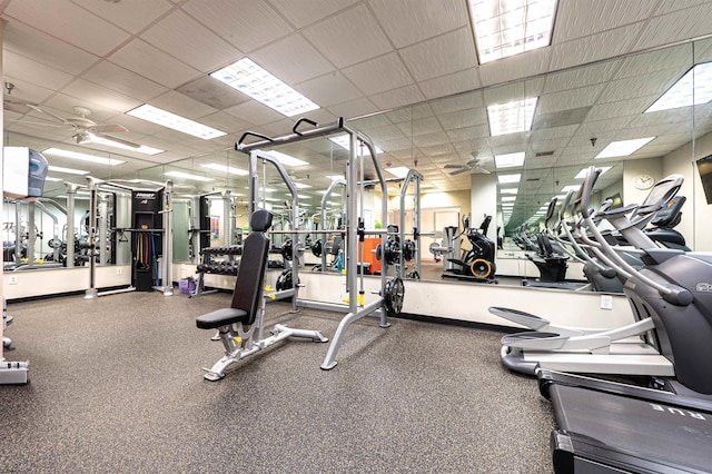 exercise room with a paneled ceiling and ceiling fan