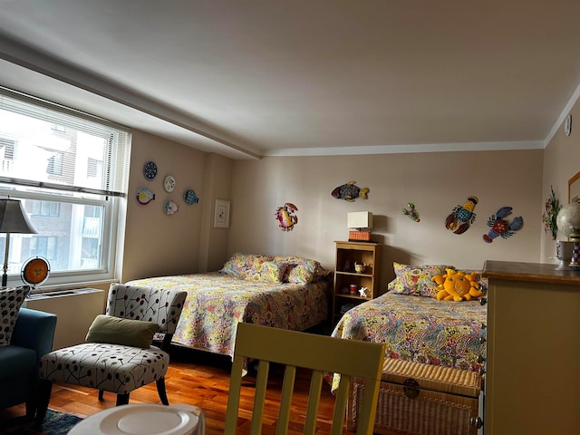 bedroom featuring ornamental molding and hardwood / wood-style flooring