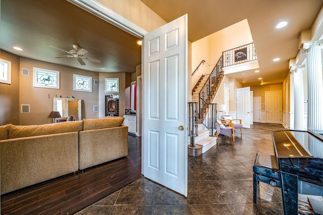 living room featuring ceiling fan and dark hardwood / wood-style flooring