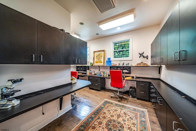 office area with built in desk and hardwood / wood-style flooring