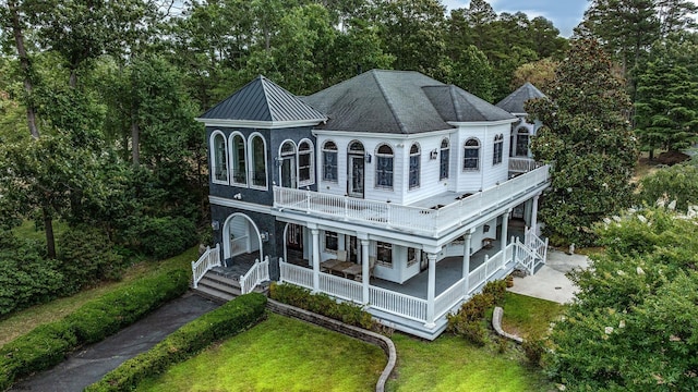 back of house with a lawn, a balcony, and a porch