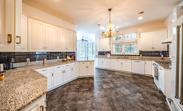 kitchen featuring backsplash, white appliances, white cabinets, and decorative light fixtures