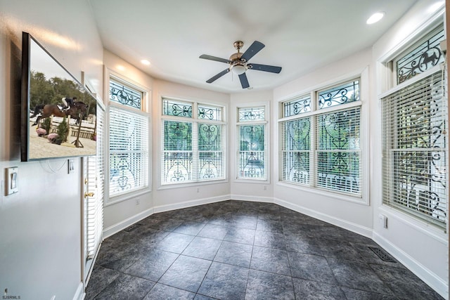 unfurnished sunroom featuring ceiling fan