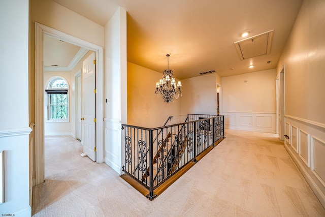 corridor with light carpet, a chandelier, and crown molding