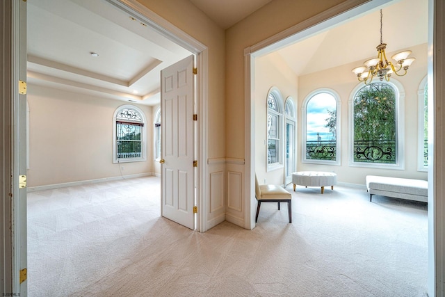 hallway with light carpet and an inviting chandelier