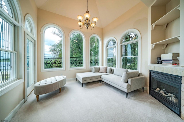 sunroom with a tile fireplace, vaulted ceiling, and an inviting chandelier