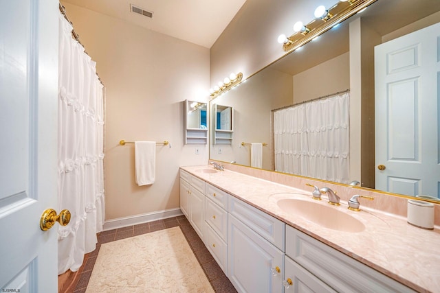 bathroom featuring tile patterned floors, vanity, and lofted ceiling