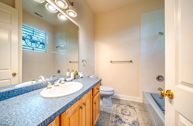 full bathroom with tile patterned floors, vanity, tiled shower / bath combo, and toilet