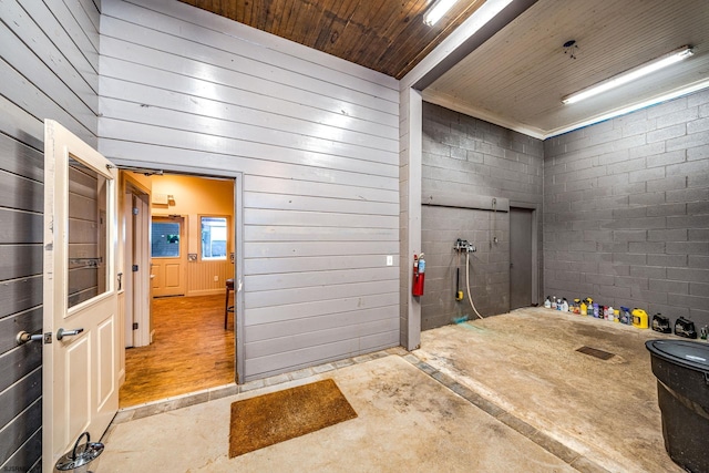 bathroom featuring wood walls, concrete floors, and wooden ceiling