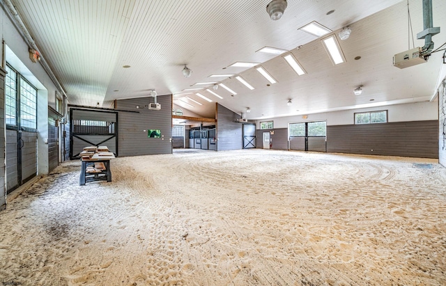 carpeted spare room featuring high vaulted ceiling