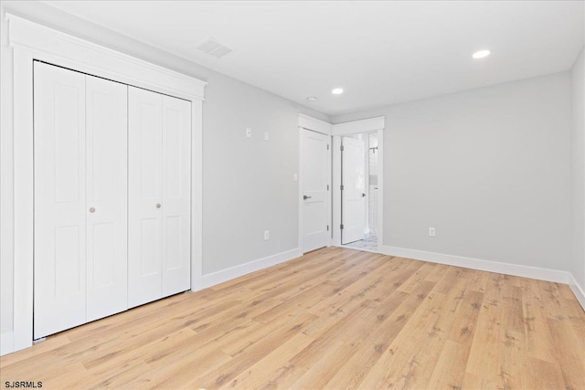 unfurnished bedroom with light hardwood / wood-style floors and a closet