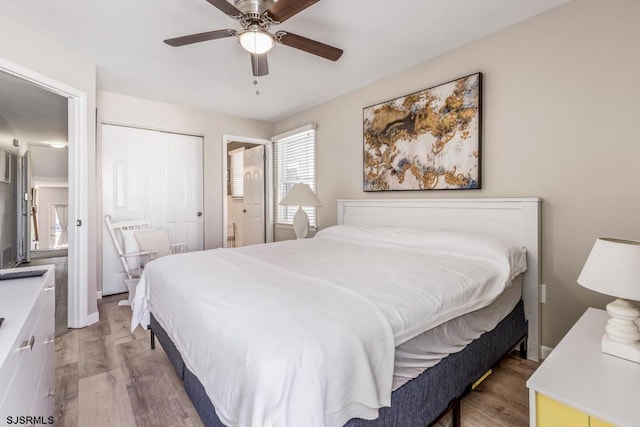 bedroom with ceiling fan, wood-type flooring, and a closet