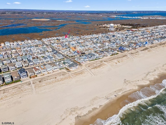 birds eye view of property with a water view and a beach view