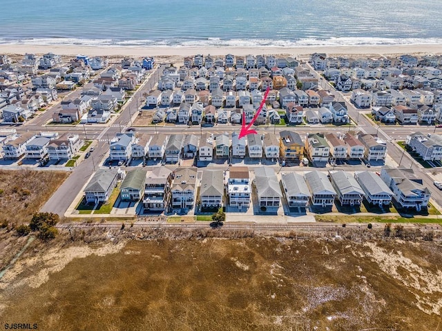 drone / aerial view with a water view and a beach view