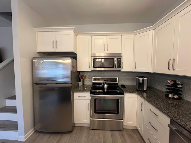 kitchen with white cabinets, light wood-type flooring, and stainless steel appliances