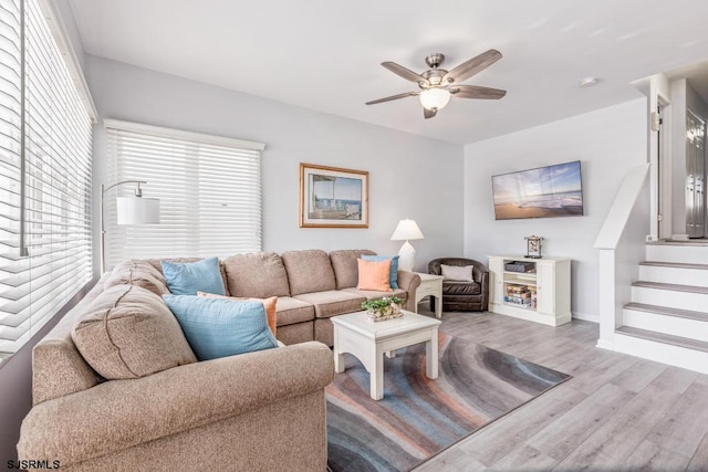 living room with light hardwood / wood-style floors and ceiling fan