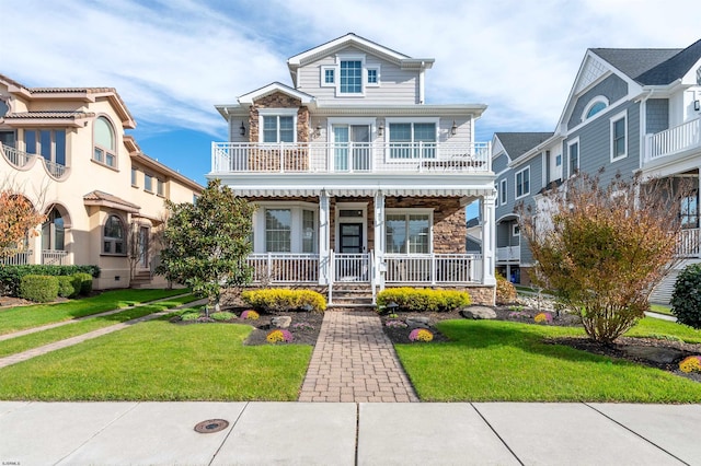 view of front of home with a porch, a balcony, and a front lawn