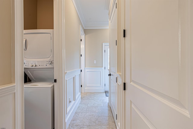 laundry room with crown molding and stacked washer and clothes dryer