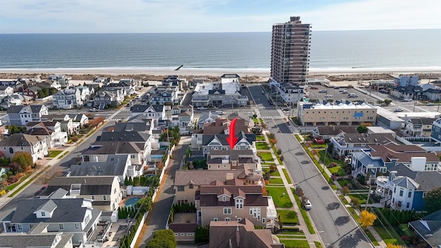 birds eye view of property featuring a water view and a beach view