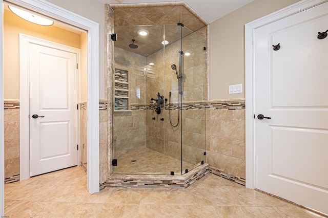 bathroom featuring an enclosed shower and tile walls