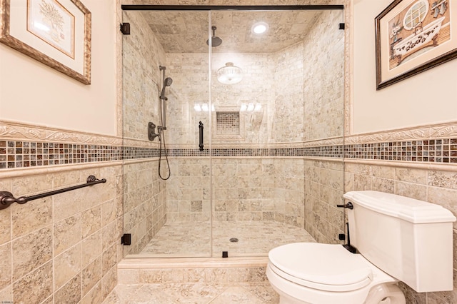 bathroom with a shower with door, toilet, and tile walls