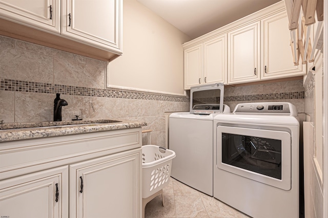 washroom with cabinets, separate washer and dryer, and sink