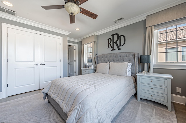 bedroom featuring ceiling fan, wood-type flooring, crown molding, and a closet