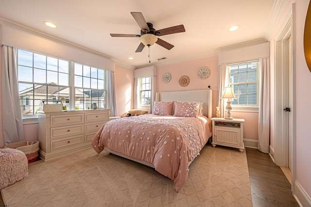 bedroom with multiple windows, ceiling fan, light hardwood / wood-style flooring, and crown molding