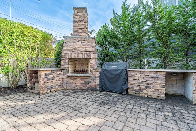 view of patio / terrace with exterior fireplace and a grill