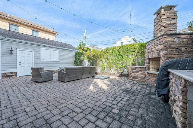 view of patio with an outdoor living space with a fireplace