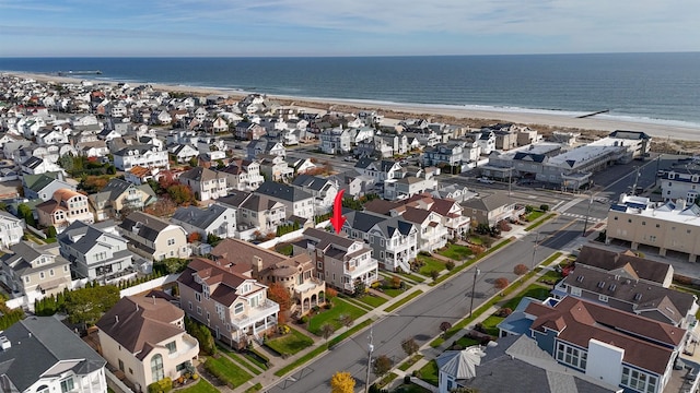 birds eye view of property with a water view and a beach view