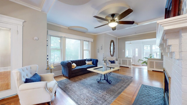 living room with radiator, ceiling fan, a wealth of natural light, and hardwood / wood-style floors