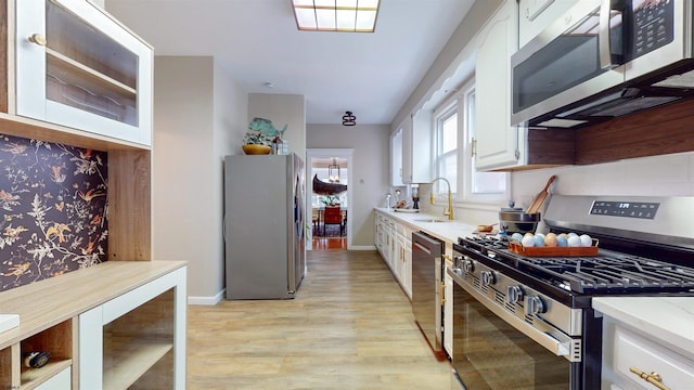 kitchen featuring white cabinetry, light hardwood / wood-style flooring, sink, and appliances with stainless steel finishes