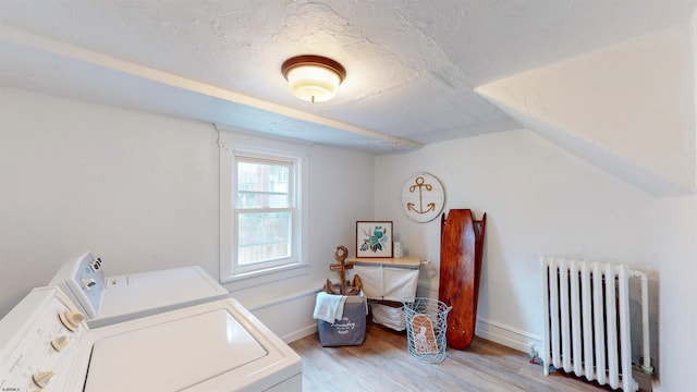 laundry area featuring light hardwood / wood-style floors, separate washer and dryer, and radiator