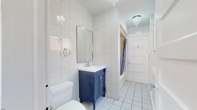 full bathroom featuring tile patterned floors, vanity, shower / bathtub combination with curtain, tile walls, and toilet