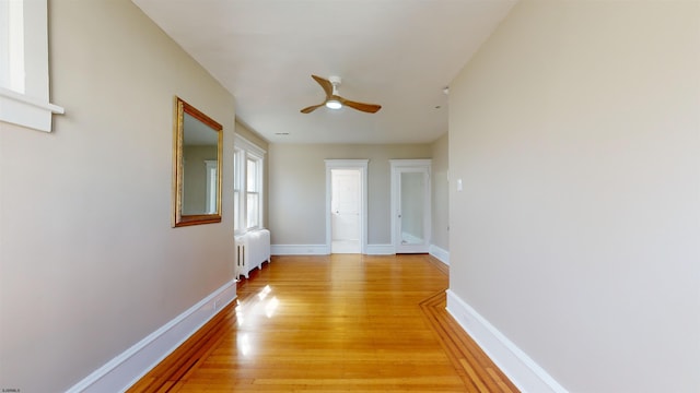 hall with radiator heating unit and light hardwood / wood-style floors