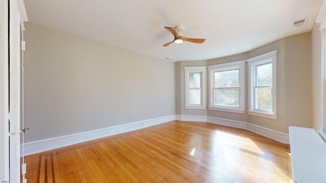 empty room with ceiling fan and light hardwood / wood-style flooring